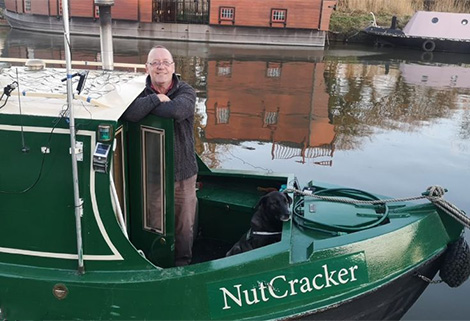 Rob (Bob) Bolton on his narrowboat NutCracker, with first mate Milo.