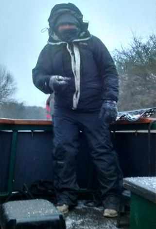 boater at the helm of a narrowboat