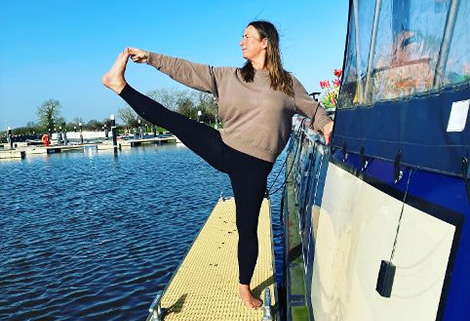 woman doing yoga on side of boat