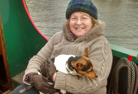 woman on narrowboat nursing jack russell pup