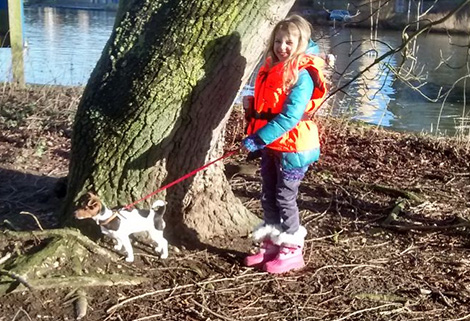 child with dog beside canal