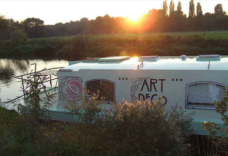 sunset behind Art Deco sunset over Art Deco wide-beam boat